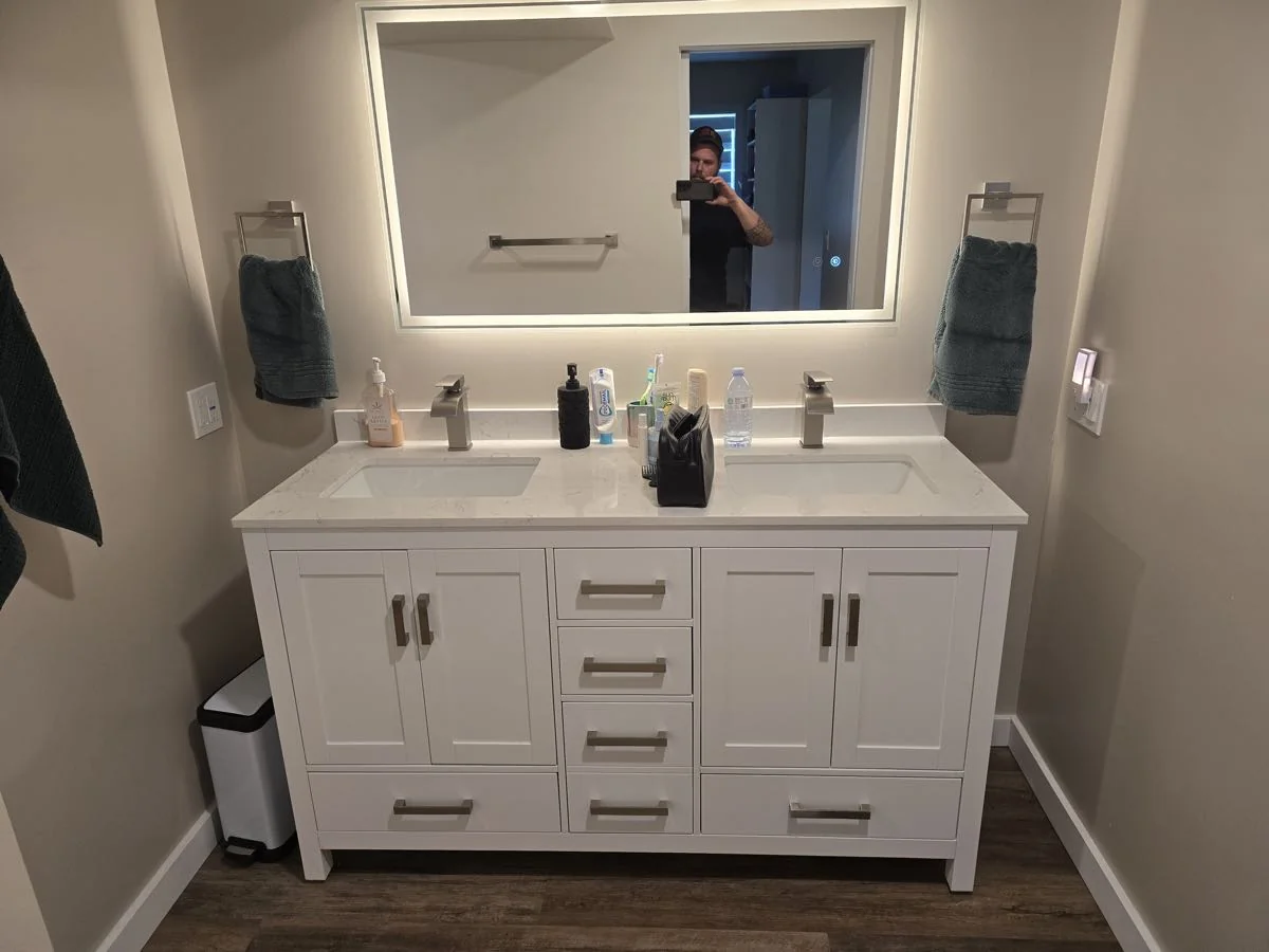 Renovated bathroom with double vanity and framed mirrors
