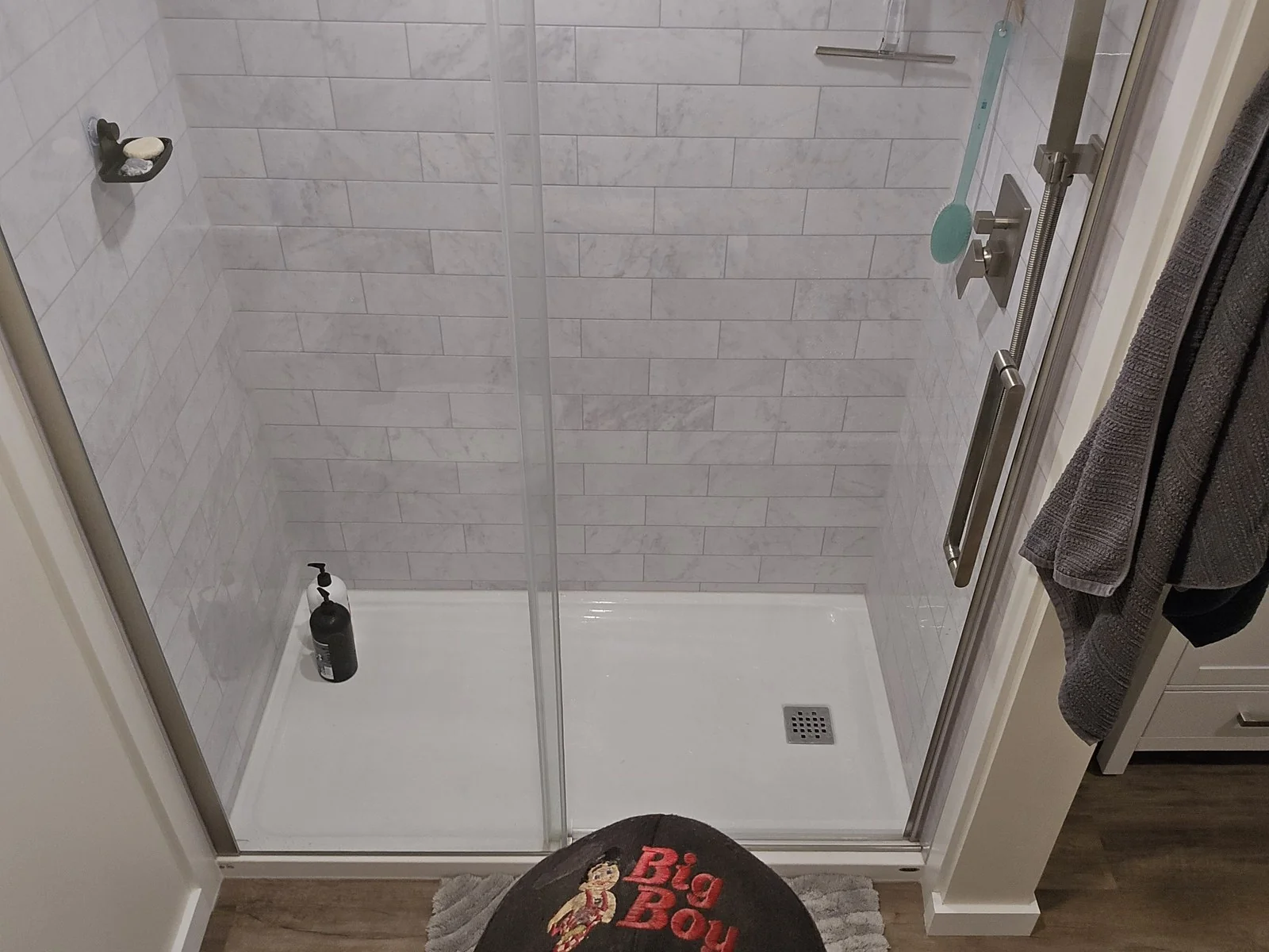 Tiled shower enclosure with a new base and glass doors