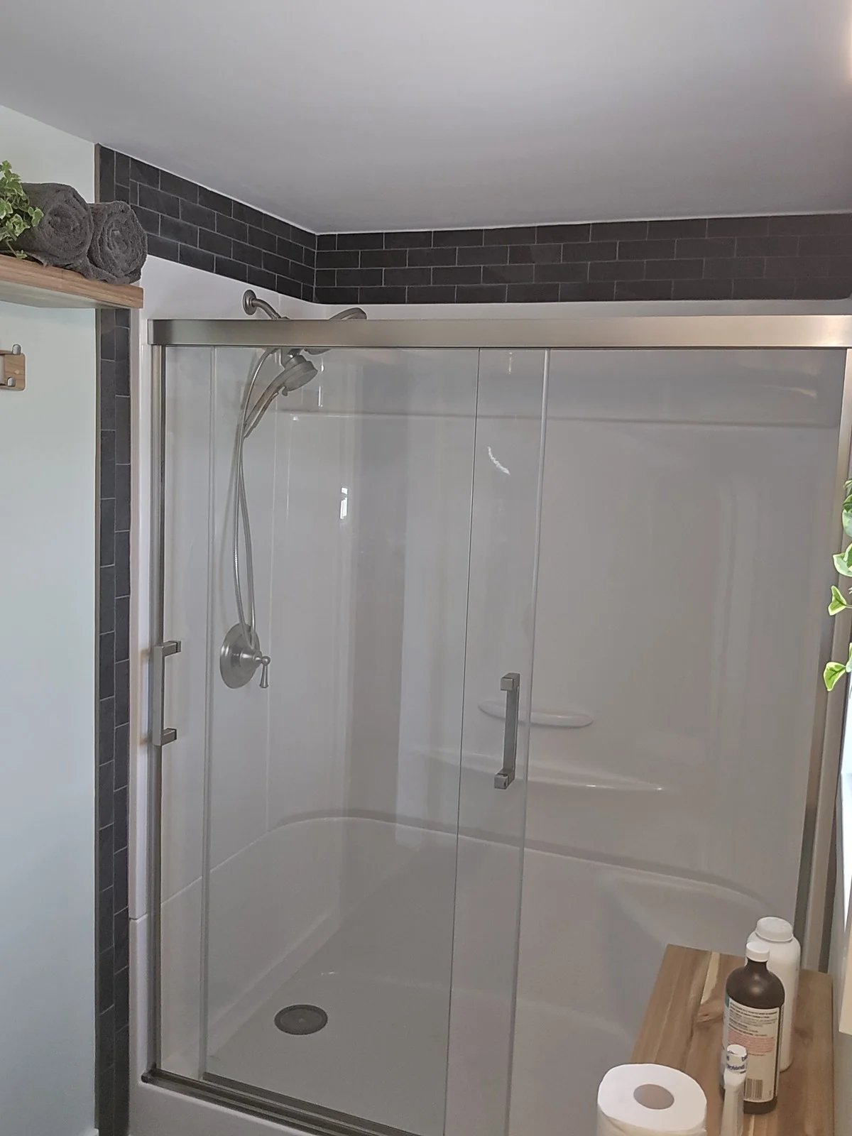 Charcoal subway tile surround above a new shower enclosure