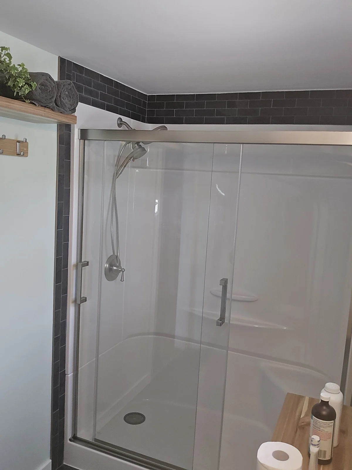 Charcoal subway tile detail framing a finished shower